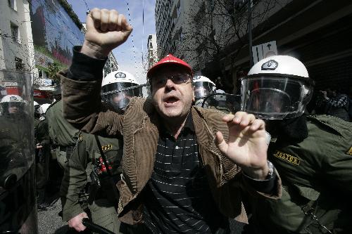 A demonstrator clashes with policemen in Athens, capital of Greece, on March 11, 2010. Violent clashes between police and groups of hooded youths broke out in central Athens on Thursday, marring a massive demonstration against government austerity measures aiming to tackle the cash-strapped country&apos;s economic troubles.[Marios Lolos/Xinhua]