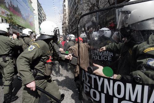 Demonstrators clash with policemen in Athens, capital of Greece, on March 11, 2010. Violent clashes between police and groups of hooded youths broke out in central Athens on Thursday, marring a massive demonstration against government austerity measures aiming to tackle the cash-strapped country&apos;s economic troubles. [Marios Lolos/Xinhua]