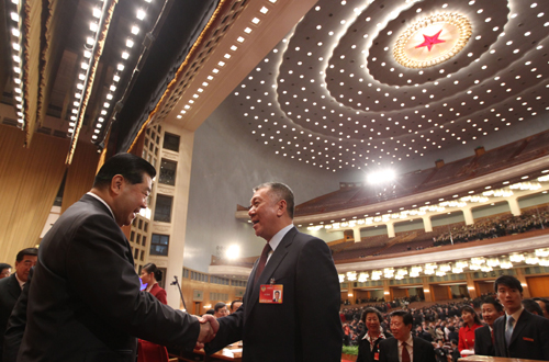 Jia Qinglin (L), chairman of the National Committee of the Chinese People's Political Consultative Conference (CPPCC), congratulates Edmund Ho Hau Wah, newly-elected vice chairman of the 11th CPPCC National Committee, after the closing ceremony of the Third Session of the 11th CPPCC National Committee at the Great Hall of the People in Beijing, capital of China, March 13, 2010. (Xinhua