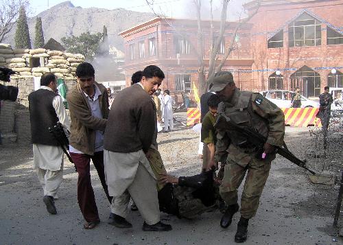 A Pakistani soldier and local residents carry an injured policeman from the site of a suicide attack in Saidu Sharif on the outskirts of Mingora. [Xinhua] 