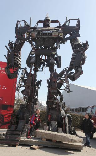 Two children look at the sculpture of 'Automan' at the performance-tuned vehicle exhibition in Beijing, China, March 12, 2010. The 10th China International Automotive Aftermarket Industry Fair and Performance-Tuned Vehicle Exhibition opened in China National Agriculture Exhibition Center on Friday. [Luo Wei/Xinhua]