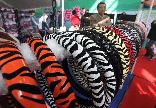 A visitor looks at the steering-wheel covers at the automotive aftermarket fair in Beijing, China, March 12, 2010. [Luo Wei/Xinhua]