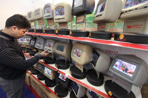 A visitor looks at vehicle televisions at the automotive aftermarket fair in Beijing, China, March 12, 2010. [Luo Wei/Xinhua]