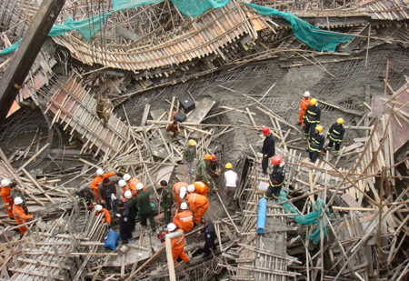 Chinese rescuers examine the debris of a collapsed passage that connects two halls of the Guiyang International Exhibition Center under construction in Guiyang, Southwest China&apos;s Guizhou province, March 14, 2010. Seven workers died and 19 were injured in the collapse, Xinhua reported. [Photo/Xinhua]