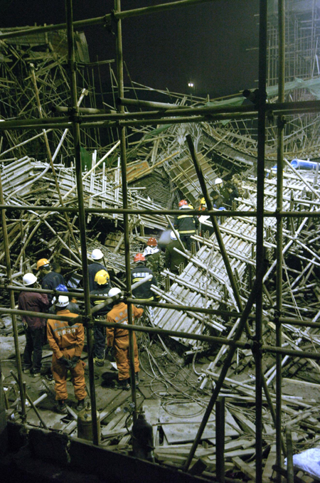 Chinese rescuers examine the debris of a collapsed passage that connects two halls of the Guiyang International Exhibition Center under construction in Guiyang, Southwest China&apos;s Guizhou province, March 14, 2010. Seven workers died and 19 were injured in the collapse, Xinhua reported. [Photo/Xinhua]