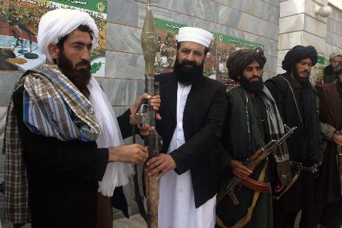 Taliban fighters defect to the government and hand over weapons to authorities in Shindand district of Herat province, Afghanistan, on March 14, 2010. Thirty Taliban fighters defected to the government here on Sunday. [Melad/Xinhua]