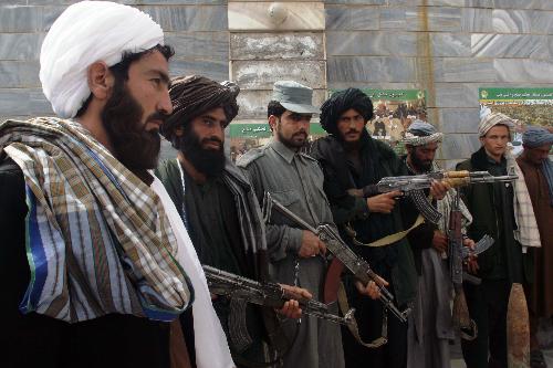 Taliban fighters defect to the government and hand over weapons to authorities in Shindand district of Herat province, Afghanistan, on March 14, 2010. Thirty Taliban fighters defected to the government here on Sunday. [Melad/Xinhua]