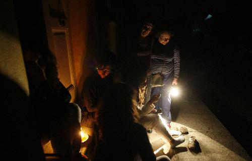 People sit outside a house during a blackout in Vina del Mar city, about 75 miles (121 km) northwest of Santiago, March 14, 2010. Cities throughout Chile were without power on Sunday evening due to a problem with one of the country's main power grids, according to witnesses and local media. [Xinhua]