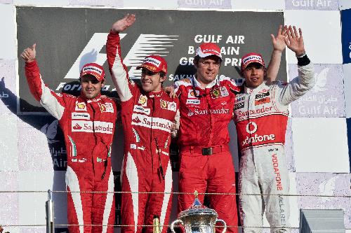 Ferrari's Felipe Massa (L1), Fernando Alonso (L2), team principal Stefano Domenicali (R2) and Vodafone McLaren's Lewis Hamilton take group photos on the podium after the Bahrain F1 Grand Prix at Sakhir circuit in Manama March 14, 2010. (Xinhua/Zhang Ning)