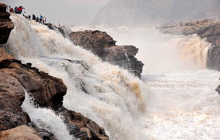 Tourists visit the Hukou Fall on the Yellow River in northwest China's Shaanxi Province, March 11, 2010. As the weather gets warmer, ice at the Hukou Fall is melted. Photo: Xinhua 