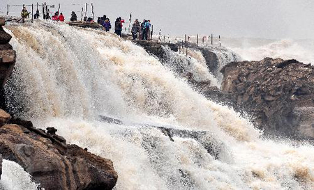 Tourists visit the Hukou Fall on the Yellow River in northwest China's Shaanxi Province, March 11, 2010. As the weather gets warmer, ice at the Hukou Fall is melted. Photo: Xinhua 