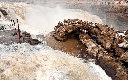 Water pours down the Hukou Fall on the Yellow River in northwest China's Shaanxi Province, March 11, 2010. As the weather gets warmer, ice at the Hukou Fall is melted. Photo: Xinhua 