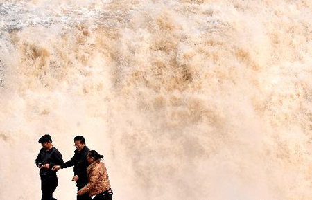 Tourists visit the Hukou Fall on the Yellow River in northwest China's Shaanxi Province, March 11, 2010. As the weather gets warmer, ice at the Hukou Fall is melted. Photo: Xinhua