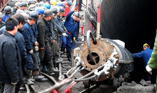 Rescue workers transport a pump in to a flooded pit of Luotuoshan Coal Mine in Wuhai City, north China's Inner Mongolia Autonomous Region, March 3, 2010. [Ren Junchuan/Xinhua]