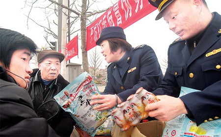 Quality inspectors teach residents in Tancheng county in East China’s Shandong province how to spot fake milk products in a campaign on Sunday to mark International Consumer Rights Day, which falls on Monday.[Fang Dehua/For China Daily]