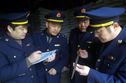 Staff of a local commerce and industry bureau test disqualified chemical fertilizer in Tancheng, east China's Shandong Province, on March 14, 2010. About 17.5 tons of disqualified chemical fertilizers were confiscated by the local authorities on the same day. [CFP Photo]