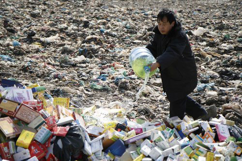 A man prepares to burn fake and expired drugs confiscated by the Tianjin Food and Drug Administration on March 10, 2010. [CFP Photo]