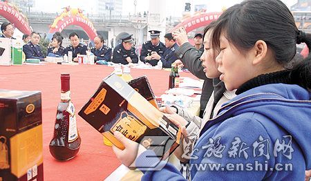 Consumers learn to distinguish genuine liquor during a consultation activity held for the annual World Consumer Rights Day in Enshi, central China's Hubei Province. 