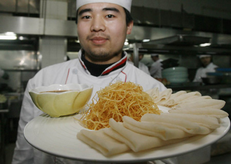 A chef displays a dish made from genetically modified potatoes in Wuhan, Hubei province.