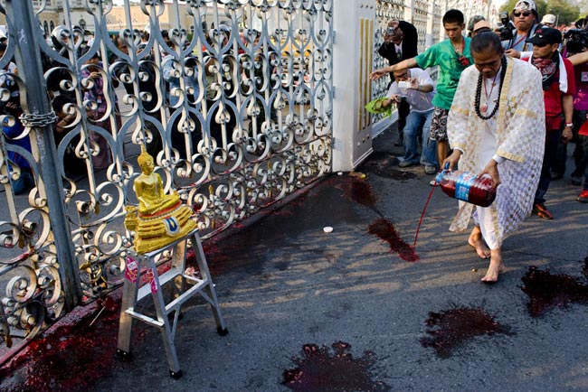 A supporter of deposed Thai Prime Minister Thaksin Shinawatra pours human blood from a cannister beside the gate of Government House on March 16, 2010 in Bangkok, Thailand. [163.com]