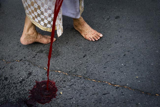 A supporter of deposed Thai Prime Minister Thaksin Shinawatra pours human blood from a cannister beside the gate of Government House on March 16, 2010 in Bangkok, Thailand. [163.com]