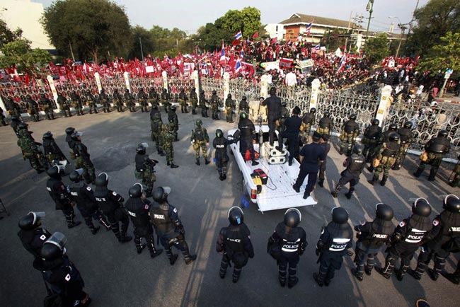 Thai soldiers stand guard as supporters of deposed Thai Prime Minister Thaksin Shinawatra gather outside the Government House on March 16, 2010 in Bangkok, Thailand. [163.com]