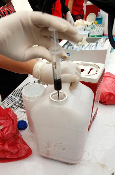 A nurse deposits blood into a bottle as supporters of deposed Thai Prime Minister Thaksin Shinawatra gather at a protest site on March 16, 2010 in Bangkok, Thailand. [163.com]