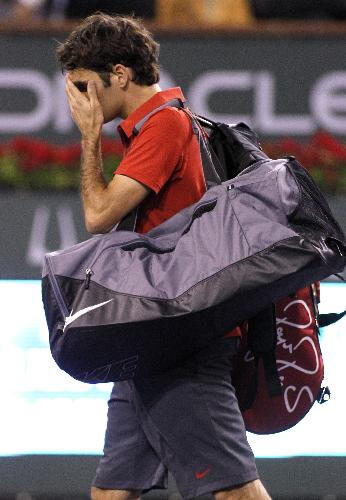 Roger Federer, of Switzerland, wipes his face as he leaves the court after being defeated by Marcos Baghdatis, of Cyprus, during their match at the BNP Paribas Open tennis tournament in Indian Wells, Calif., Tuesday, March 16, 2010. (Xinhua/Reuters Photo)