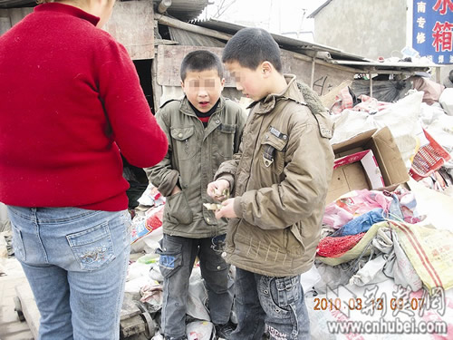 The two children, who collected garbage in order to pay for their internet-surfing bills, negotiate a price for their trash at a recycling station in Changfeng County, central China's Wuhan city on Saturday, March 13, 2010. [Photo: cnhubei.com]