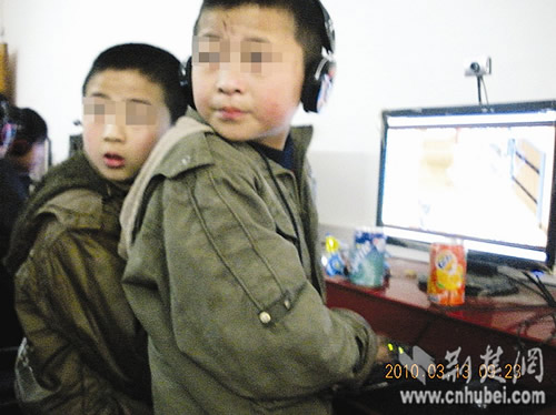 The two pupils surf the internet after they receive money for the garbage they collected from a recycling station in Changfeng County, central China's Wuhan city on Saturday, March 13, 2010. [Photo: cnhubei.com] 