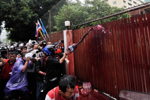 A Thai red-shirted demonstrator pours blood at the gate of Prime Minister's house in Bangkok, Thailand, March 17, 2010. Thailand's red-shirts demonstrators poured blood at the gate of Prime Minister's house at about 12:00 a.m. local time Wednesday after they initiated the blood-pouring tactic Tuesday at the Government House and the headquarters of the ruling Democrat Party.[Lui Siu Wai/Xinhua]