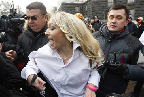 Police detain a member of women&apos;s activist group FEMEN, in front of the Cabinet in Kiev, Ukraine, Wednesday, March 17, 2010. [CRI]