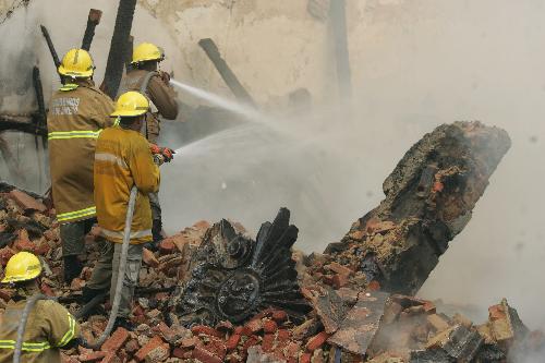 Firefighters try to extinguish the fire of a building in the center of Rio de Janeiro, Brazil, March 18, 2010. After two hours&apos; working, firefighters controlled the fire. [Agencia Estado/Xinhua]