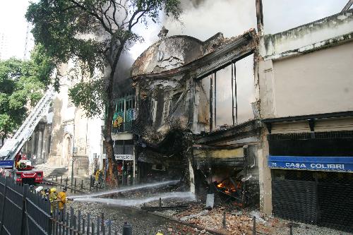 Firefighters try to extinguish the fire of a building in the center of Rio de Janeiro, Brazil, March 18, 2010. After two hours&apos; working, firefighters controlled the fire.[Agencia Estado/Xinhua] 