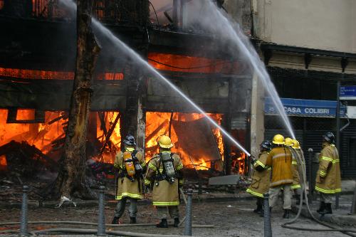 Firefighters try to extinguish the fire of a building in the center of Rio de Janeiro, Brazil, March 18, 2010. After two hours&apos; working, firefighters controlled the fire.[Agencia Estado/Xinhua]