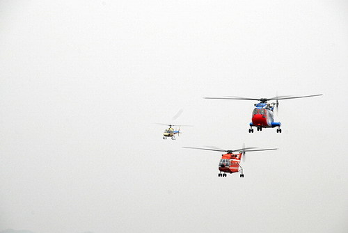 A giant AC313 helicopter(R first) flies accompanied by two helicopters during its test flight over east China's Jiangxi province on March 18. [Photo/Chinanews.com.cn]
