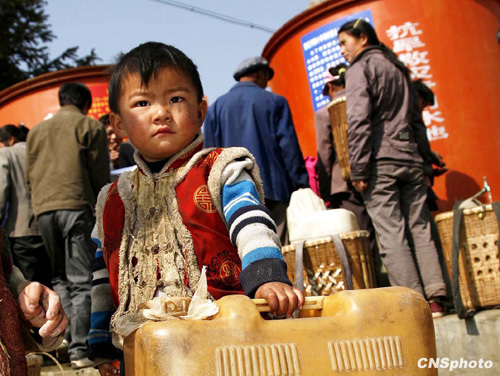 A child is lining up for drinking water in Xiaoyangchang Village, Fuyuan County of Yunnan Province, on March 12, 2010. Parts of southern China are being ravaged by a severe three-season drought. More than 20 million of people lack adequate water supplies, and millions of acres of cropland are too dry to plant.