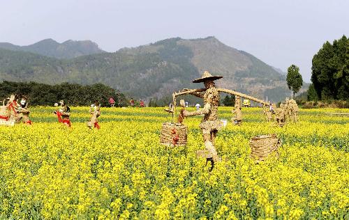 Straw men are seen in the cole field at the Shenxianju scenic area in Taizhou City, east China's Zhejiang Province, March 18, 2010.