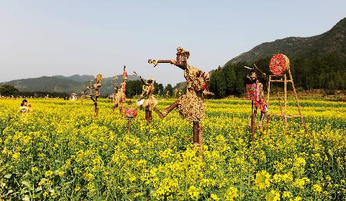 Straw men are seen in the cole field at the Shenxianju scenic area in Taizhou City, east China's Zhejiang Province, March 18, 2010. 