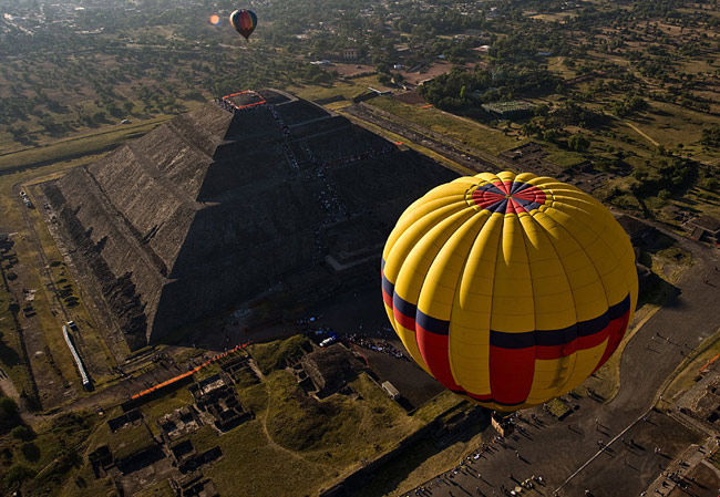 A hot air balloon floats past people watching the sunrise at the Sun pyramids of Teotihuacan during a festival as part of the spring equinox outside Mexico City March 21, 2010. Hundreds of Mexicans and tourists gather at Teotihuacan every year to welcome spring equinox at the Pyramid of the Sun. [Xinhua/Reuter]