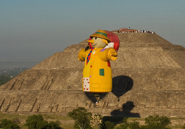 A hot air balloon floats past people watching the sunrise at the Sun pyramids of Teotihuacan during a festival as part of the spring equinox outside Mexico City March 21, 2010. Hundreds of Mexicans and tourists gather at Teotihuacan every year to welcome spring equinox at the Pyramid of the Sun. [Xinhua/Reuter]