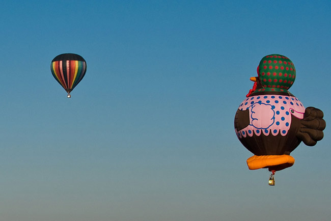 Hot air balloons float past people watching the sunrise at the Sun pyramids of Teotihuacan during a festival as part of the spring equinox outside Mexico City March 21, 2010. Hundreds of Mexicans and tourists gather at Teotihuacan every year to welcome spring equinox at the Pyramid of the Sun. [Xinhua/Reuter]