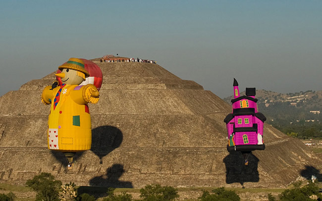 Hot air balloons float past people watching the sunrise at the Sun pyramids of Teotihuacan during a festival as part of the spring equinox outside Mexico City March 21, 2010. Hundreds of Mexicans and tourists gather at Teotihuacan every year to welcome spring equinox at the Pyramid of the Sun. [Xinhua/Reuter]