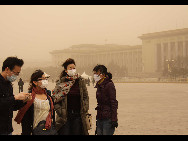 Tourists visit the Tian'anmen Square in sand-dust weather in Beijing, capital of China, March 22, 2010. The Central Meteorological Station issued a blue alert for sandstorms at 6 AM on Monday. [Xinhua]