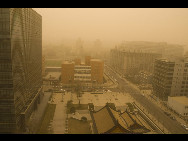 Permeating yellow sands suffuse over the financial avenue on the western ring road in downtown Beijing, March 22, 2010. A sand-dust weather pervades Beijing once again, as the Central Meteorologic Station issued blue alert signal for sandstorm attack on 6 am. [Xinhua]