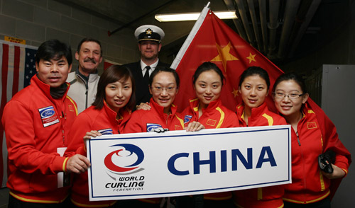 Team members of China have a group photo taken with volunteers before the first round match against Germany in the World Women's Curling Championships in Swift Current, Saskatchewan, March 20, 2010. (Xinhua/Zou Zheng)