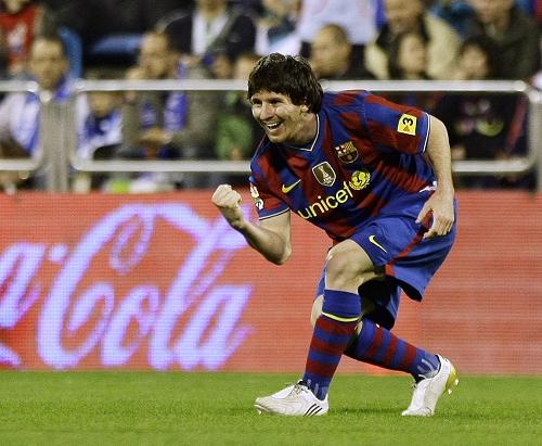 Barcelona's Lionel Messi celebrates his second goal against Zaragoza goalkeeper Roberto during their Spanish first division soccer match at La Romadera stadium in Zaragoza March 21, 2010. 