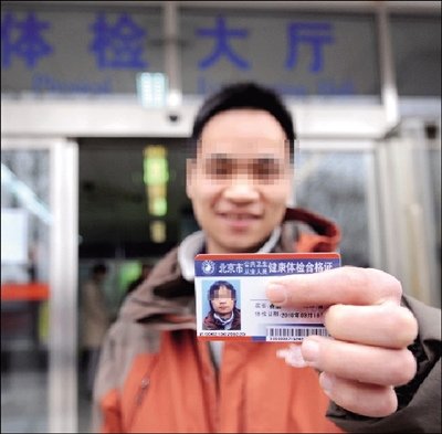 The Hepatitis B carrier, surnamed Liao shows his health certificate.