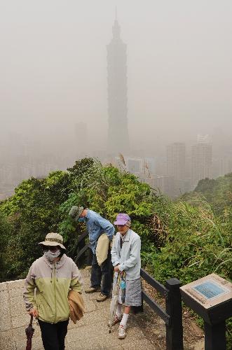 Local elders wearing masks take a break on a path up to a hill amid a floating dust weather in downtown Taipei, southeast China's Taiwan, March 21, 2010. A sandstorm hit the island on Sunday. (Xinhua/Wu Ching-teng)