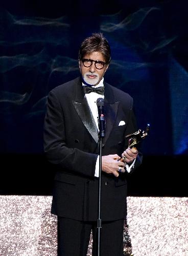 Indian actor Amitabh Bachchan holds the trophy after winning the Lifetime Achievement Award at the Asian Film Awards in Hong Kong, south China, on March 22, 2010.